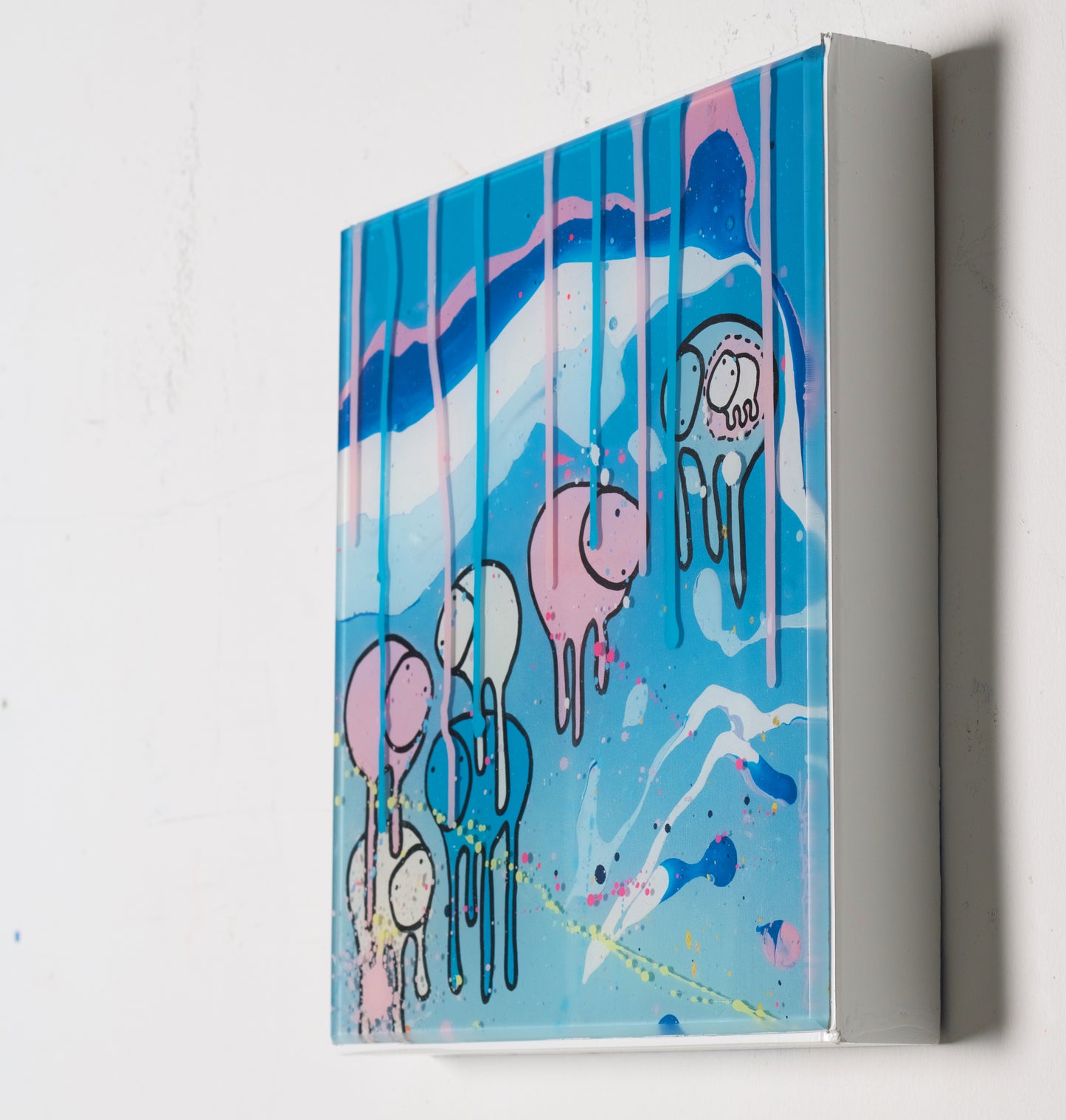 Side view of painting RAINING COWS 'Chilli Chill' by Toronto artist Morgan Sheardown hanging on a white wall, showing colorful pink, white and blue swirls, dripping pink paint, and cows.