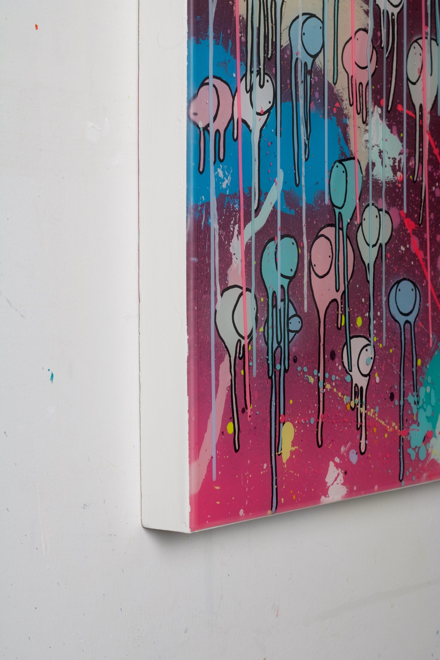 Side view of resin abstract artwork with colorful splashes and shapes on a white wall