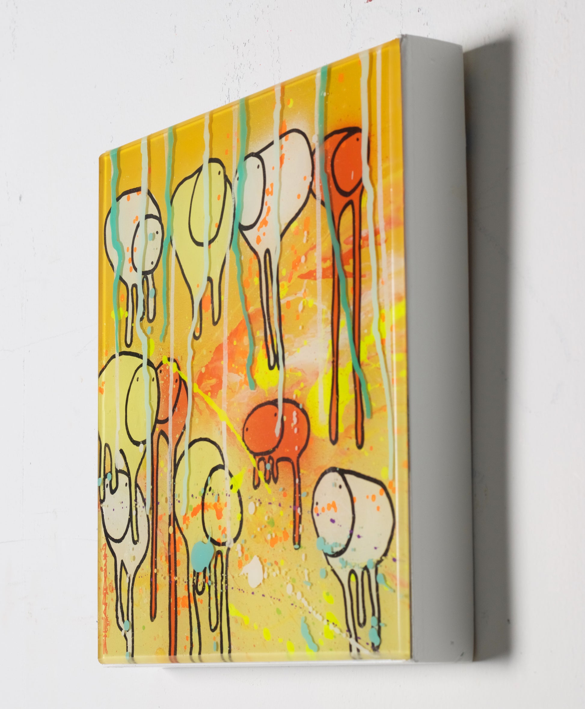 Side view of 12x12 painting RAINING COWS 'Eternal Sunshine in the Rain'  by Toronto artist Morgan Sheardown hanging on a white wall, showing colorful yellow and orange swirls, dripping paint, and cows.
